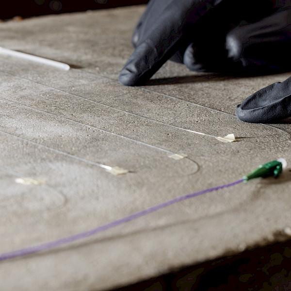 Installation of fibre-optic measurement technology on concrete for the continuous monitoring of strains and cracks.